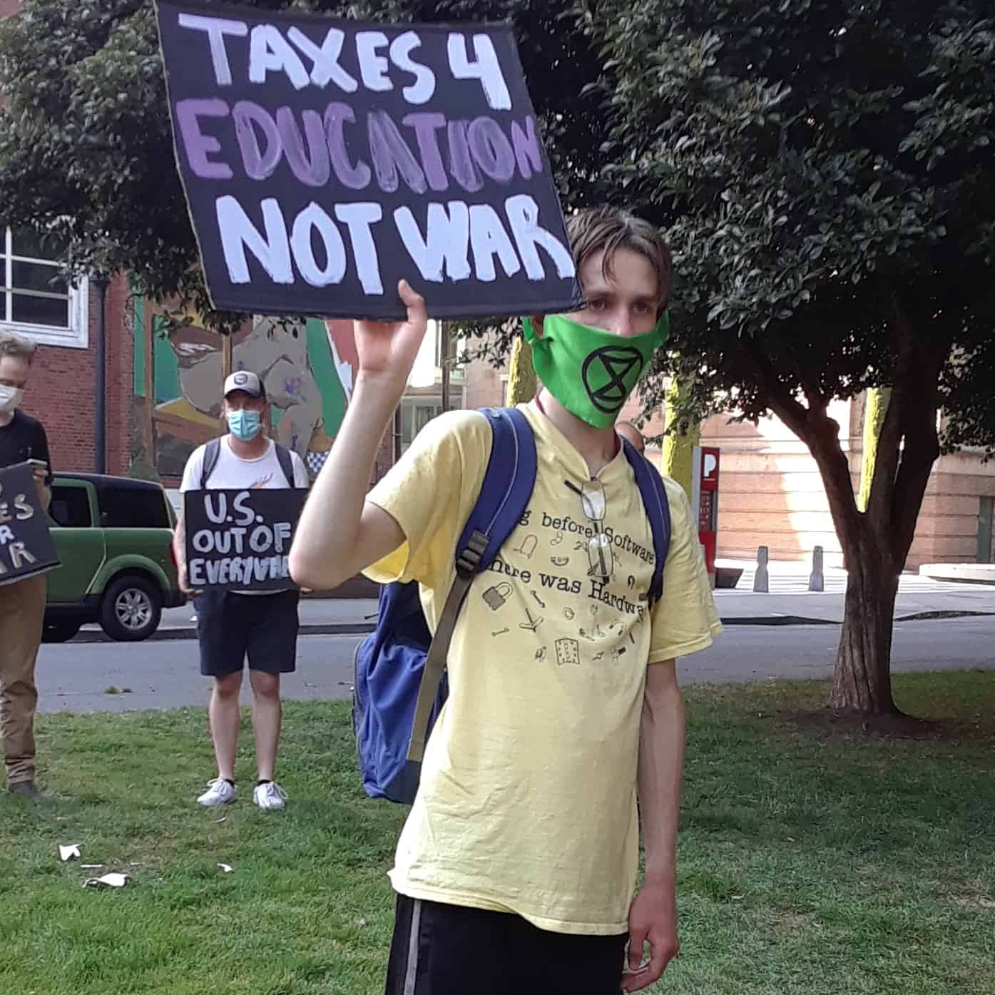 Protester sign: Taxes for education, not war.