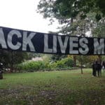 A long "BLACK LIVES MATTER" banner hangs in Peninsula Park.