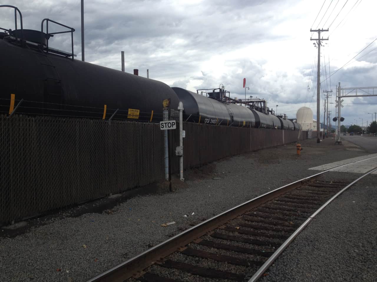 An oil train sits idle behind a fence along Front Ave in Northwest Portlland