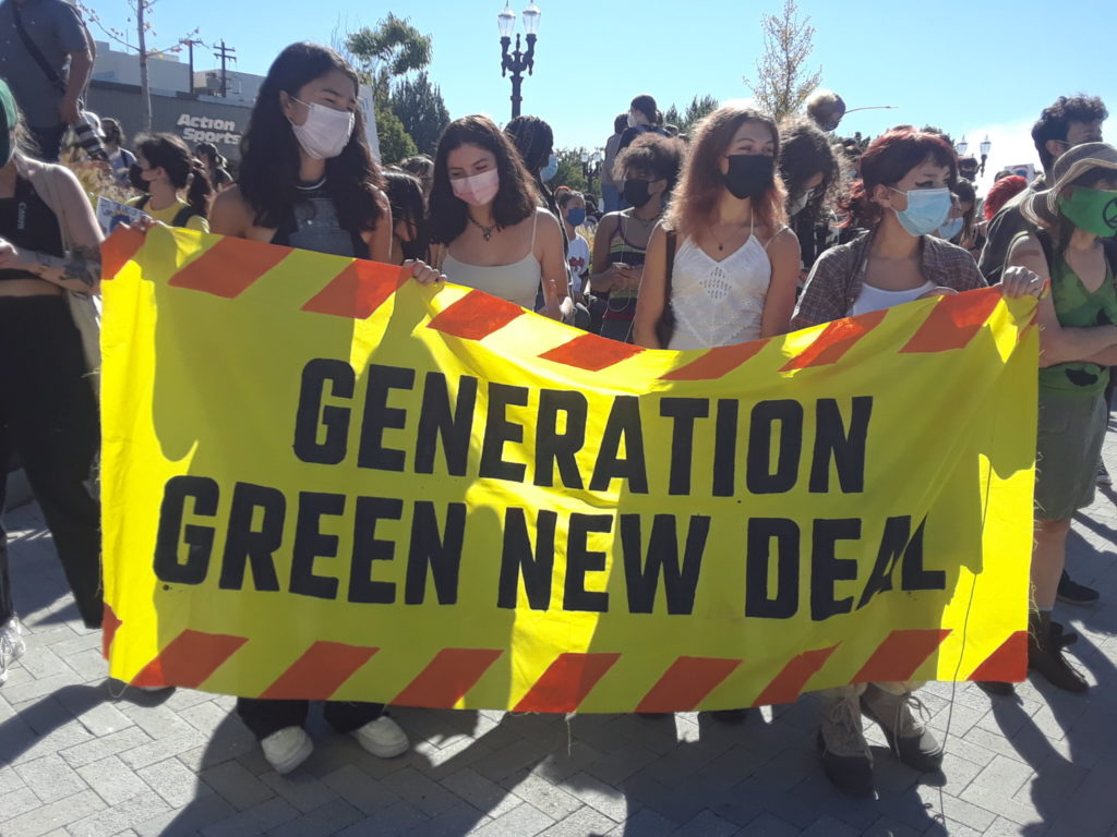 4 high school students holding "Generation Green New Deal" banner