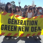 4 high school students holding "Generation Green New Deal" banner