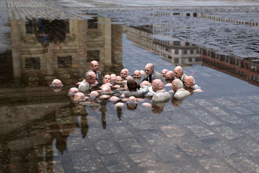 A sculpture by Isaac Cordal--Follow the leaders. It depicts global leaders as balding men of European descent groping around in water (the rising sea) up to their chests.