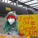 Youth climate activist holding sign saying "Zenith Oil = Climate Crime"