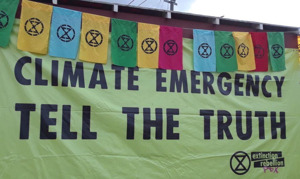 Extinction Rebellion PDX banner that says: "Climate Emergency/ Tell the Truth"