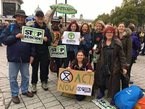 Affinity group in the UK, holding signs "Stop Ecocide"