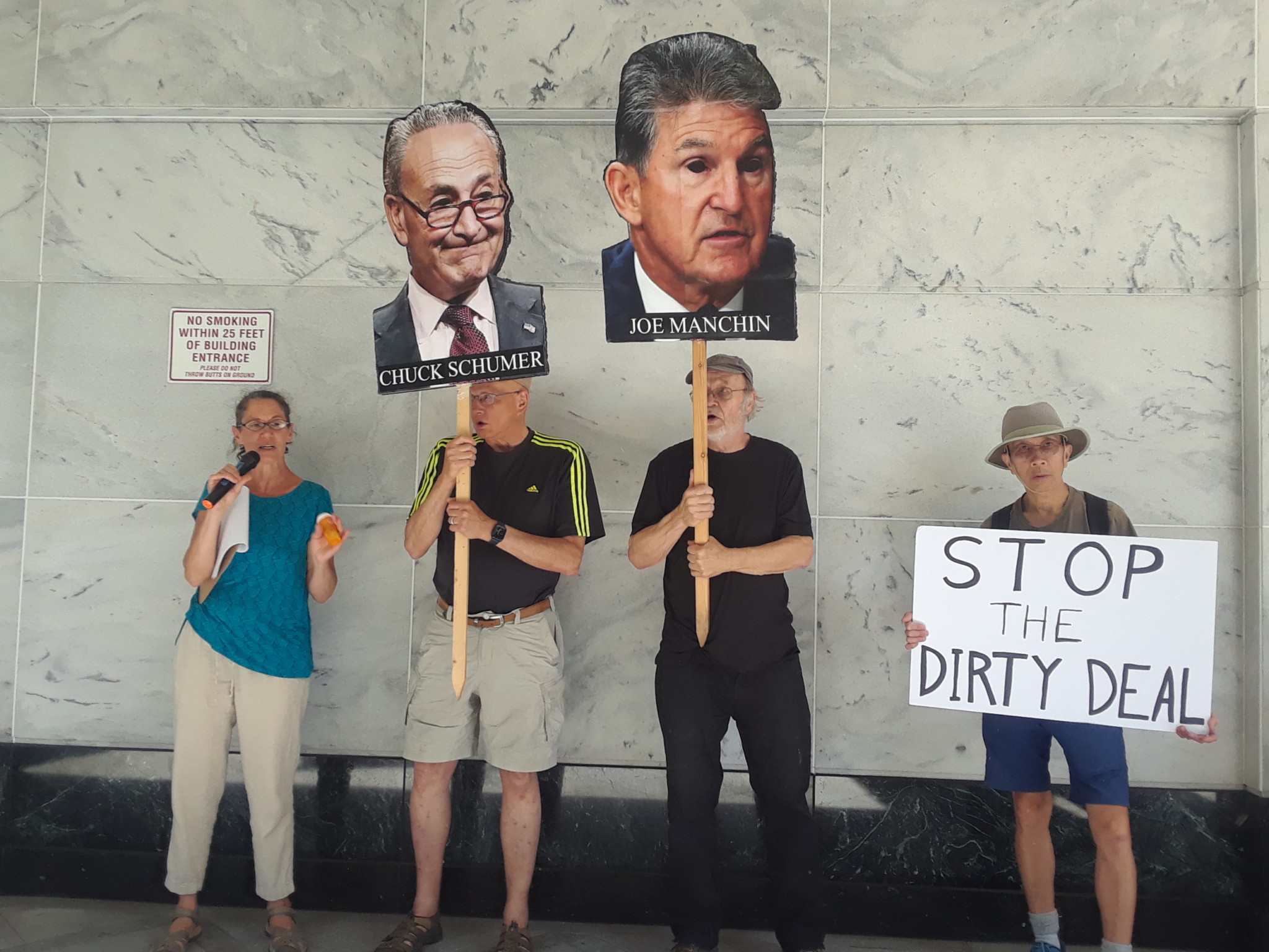 Photo of 4 people holding signs about Manchin's dirty deal
